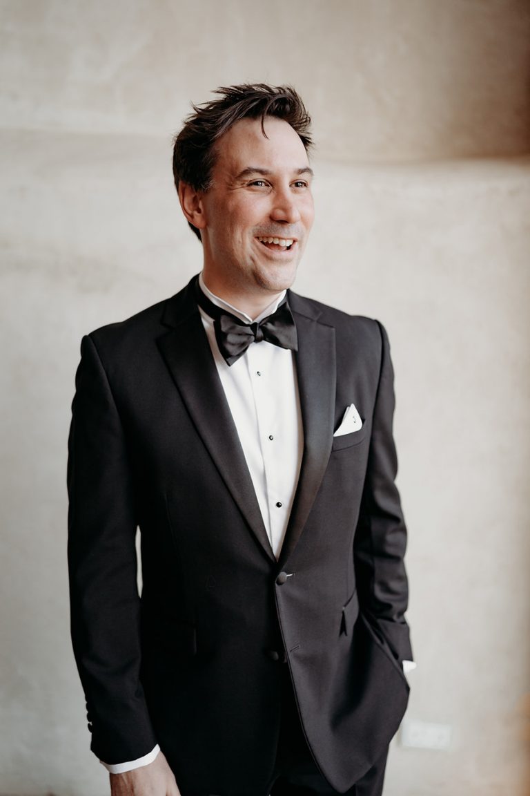 Groom Jeremy looking sharp in his black tie suit, ready to marry his soul mate and puzzle piece, Rebecca