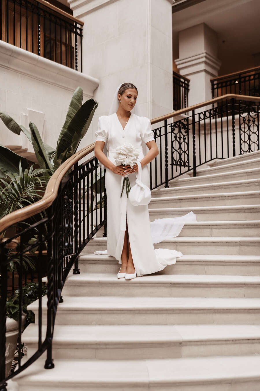 Bride Monda wearing a short sleeved, open back, modern BON BRIDÉ wedding dress.