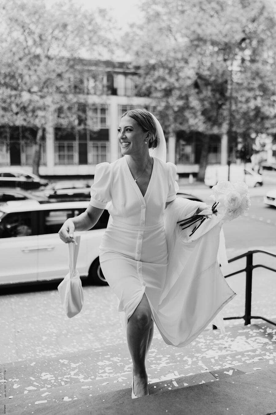 Bride Monda wearing a short sleeved, open back, modern BON BRIDÉ wedding dress.