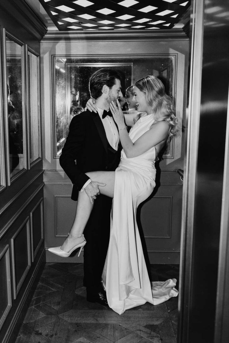 Bride Monda looking glamourous wearing an open backed, high neck Milla dress with a dramatically high thigh split
