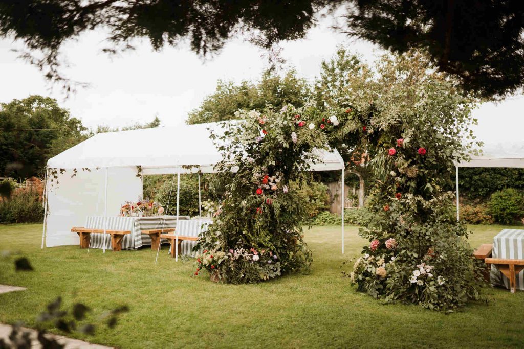 Dramatic floral arch installation for Sophie + Etham's summer garden party wedding