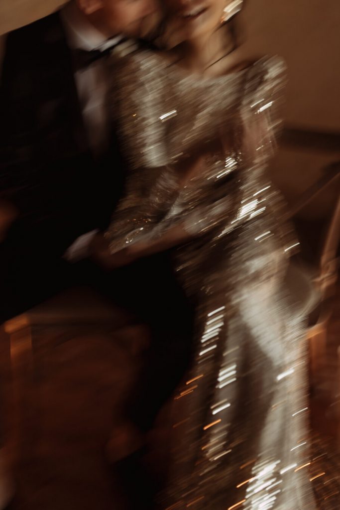 Julita London's exquisite Gilded Lily dress subtly shimmers as the flickering candle light casts a glow against the iridescent fabric