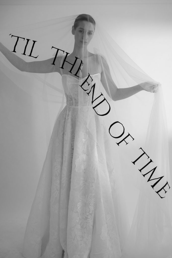 A sheer veil with a bold font in black thread emblazoned across the hem that reads "'Til the end of time"